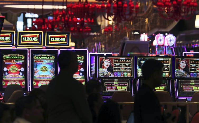 Sillouettes of faces can be seen against slot machines and other gambling devices