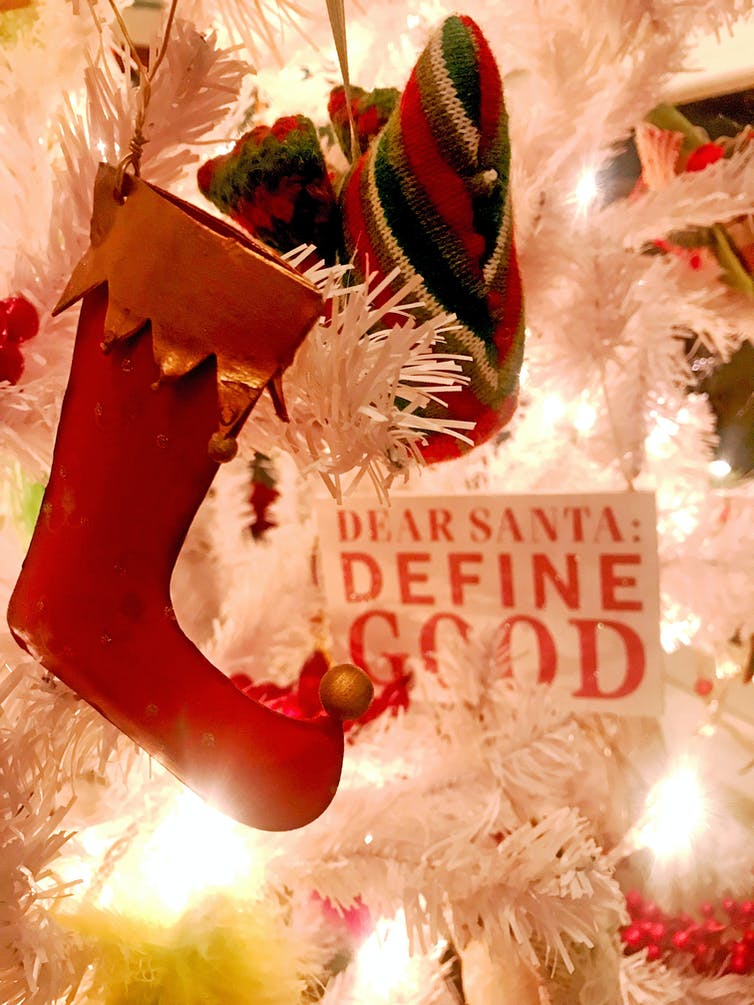 A Christmas stocking and a sign that says 'Define good'