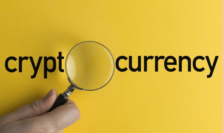 A magnifying glass over the word cryptocurrency.